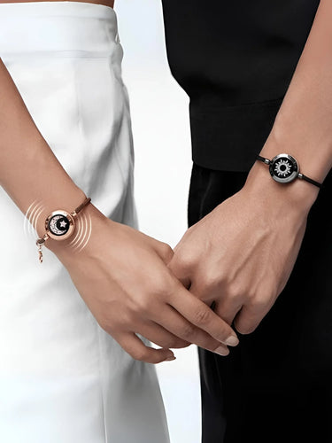 Two wrists wearing matching bracelets with a white and black background
